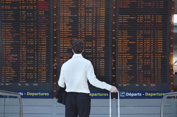 Man looking at airport departure board Man looking at airport departure board