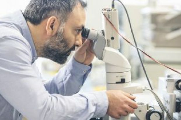 man looking through microscope man_looking_through_microscope