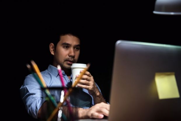 Man working at computer in evening