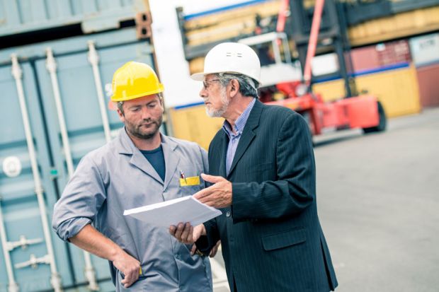 Men discussing paperwork on ship dock Men discussing paperwork on ship dock