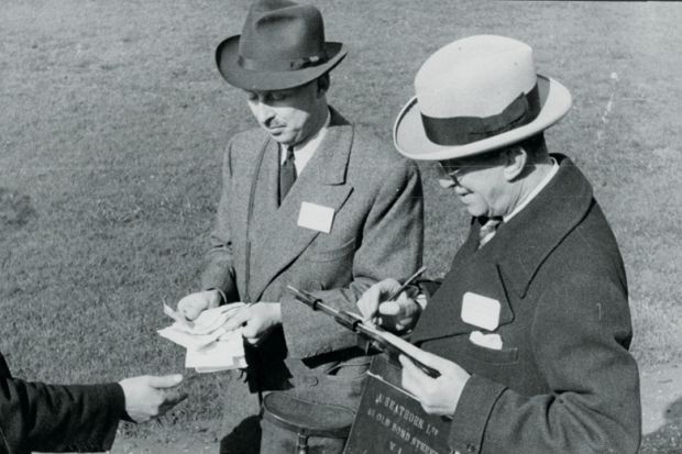 Men paying out winnings at a racecourse Men paying out winnings at a racecourse