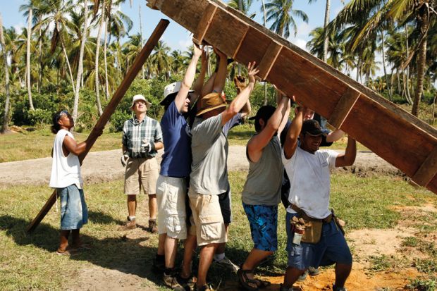 Men lifting wooden construction frame, Tasbapauni, Nicaragua Men lifting wooden construction frame, Tasbapauni, Nicaragua