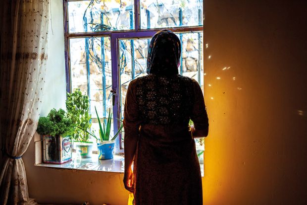 Iranian Kurdish woman who was circumcised at eight stands in silhouette by a window Iranian Kurdish woman who was circumcised at eight stands in silhouette by a window