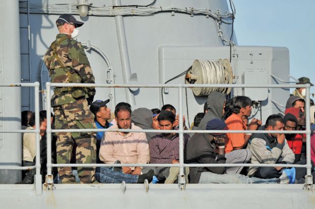 Migrants sitting on a rescue ship Migrants sitting on a rescue ship