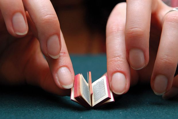 Person reading miniature book Person reading miniature book