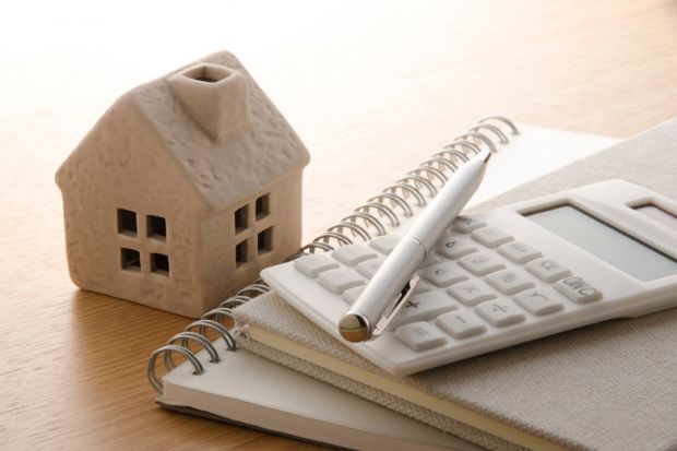 Model of house with calculator and notepads