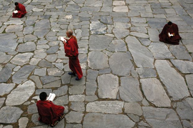 Monks studying books in the courtyard Monks studying books in the courtyard