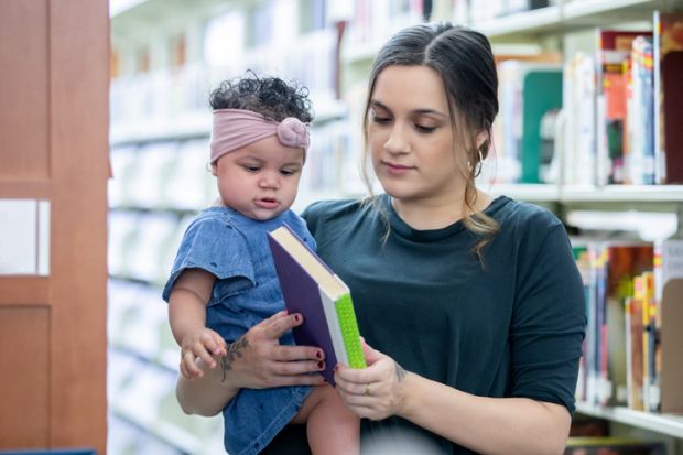 A mother with her daugher in a library, illustrating academic parenthood