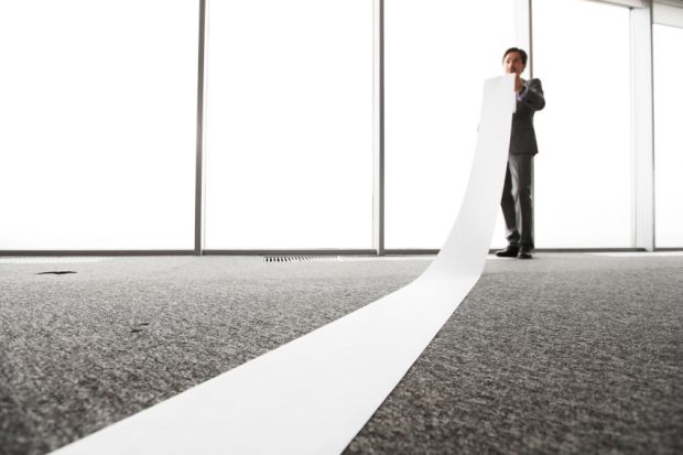 Office worker unrolling long sheet Office worker unrolling long sheet