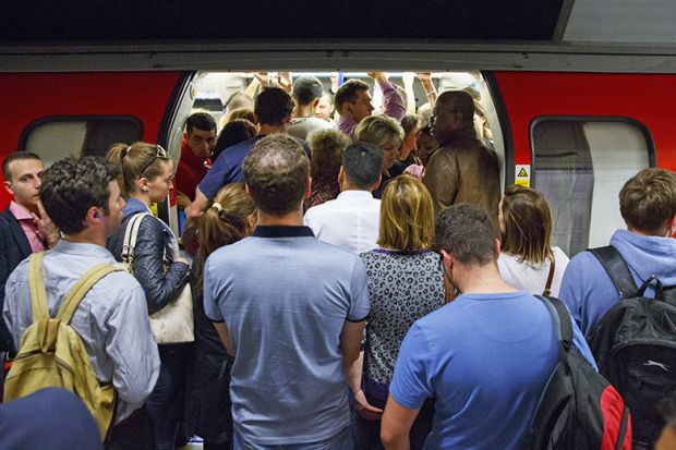 Commuters queuing for tube trains at Green Park Tube Station in evening rush hour in London, England. To illustrate that universities are churning out PhD graduates that have little prospect of securing an academic job.