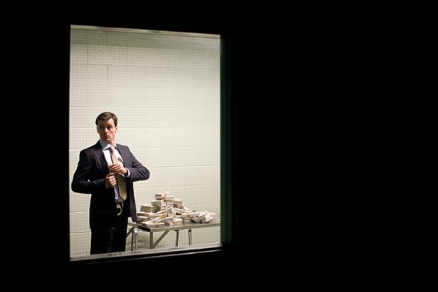 Man putting cash in his pocket behind closed door