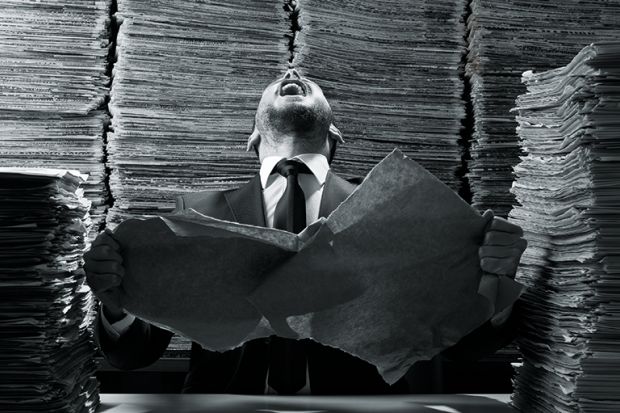 A man laughing amid a pile of paperwork A man laughing amid a pile of paperwork