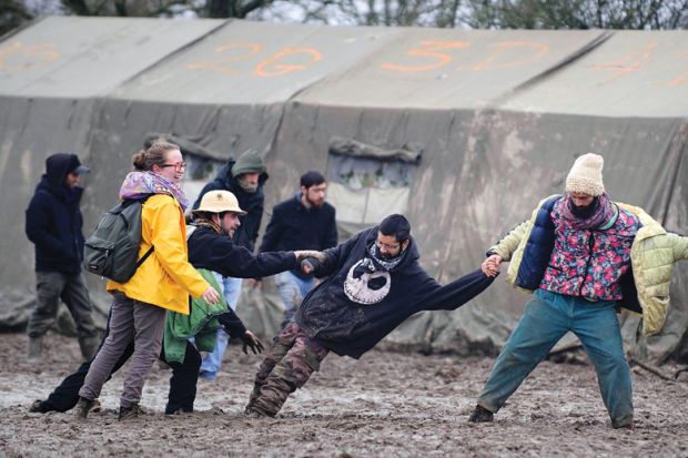 People help man stuck in mud at music festival, Notre-Dame-des-Landes, France People help man stuck in mud at music festival, Notre-Dame-des-Landes, France
