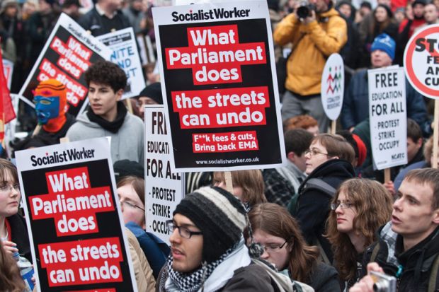 People holding signs at a protest People holding signs at a protest