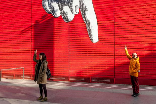 Tourists holding up their fingers, under a giant cartoon finger outside the National Gallery, London, England. To illustrate a government proposal to take a cut of overseas income to pay for HE dismissed as ‘finger in the air" policymaking Tourists holding up their fingers, under a giant cartoon finger outside the National Gallery, London, England. To illustrate a government proposal to take a cut of overseas income to pay for HE dismissed as ‘finger in the air" policymaking