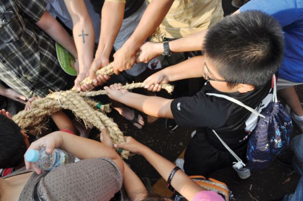 People pulling rope during tug of war festival People pulling rope during tug of war festival