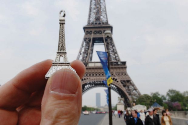 Person holding model in front of Eiffel Tower, Paris, France Person holding model in front of Eiffel Tower, Paris, France