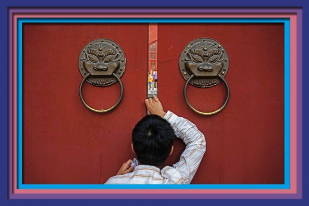 A person peeks through the large doors of the historic Drum Tower during the Golden Week holiday on October 3, 2024 in Beijing, China. To illustrate that China lags on global collaboration. A person peeks through the large doors of the historic Drum Tower during the Golden Week holiday on October 3, 2024 in Beijing, China. To illustrate that China lags on global collaboration.