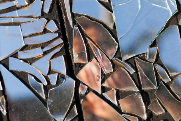 Person reflected in shattered mirror