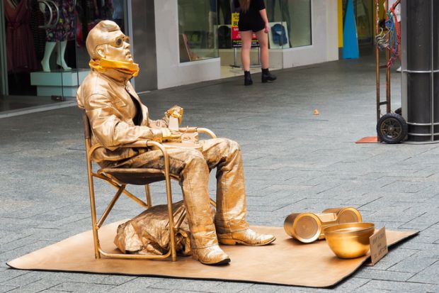 Perth, Western Australia, Australia - November 28, 2014 Gold Painted Man is sitting in front of London Court, a tourist spot of Perth City Center, Australia