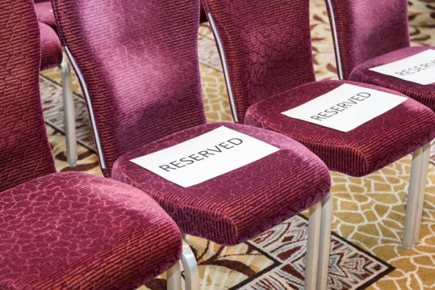 Red rows of chairs with white sheets reserved