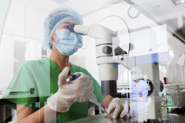 Researcher with microscope in lab