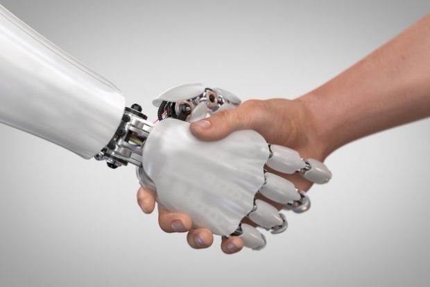 A robot hand shakes a human hand