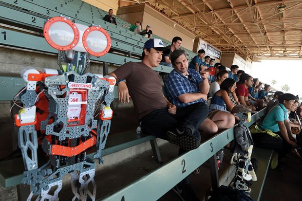 A robot sitting with spectators