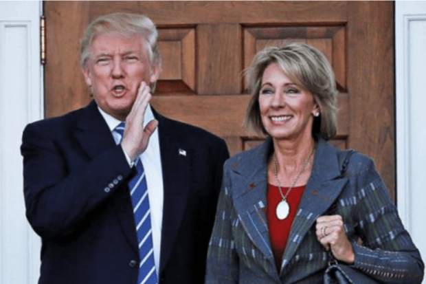 Donald Trump standing with Betsy DeVos