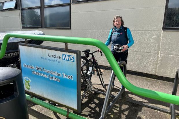 Shunna Burke after cycling to hospital , stood by NHS sign