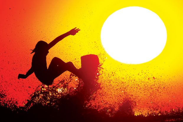 Silhouette of person surfing on wave at dawn Silhouette of person surfing on wave at dawn