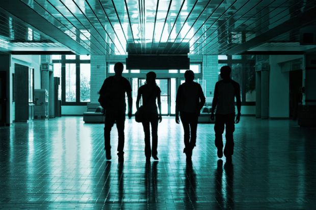 Silhouettes of students walking in university hallway Silhouettes of students walking in university hallway