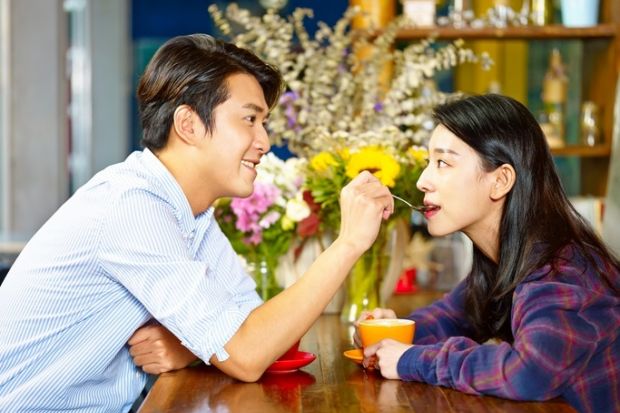 Spoon-feeding A man spoon-feeding a woman