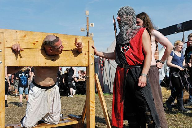 A man in stocks at a modern-day fete A man in stocks at a modern-day fete