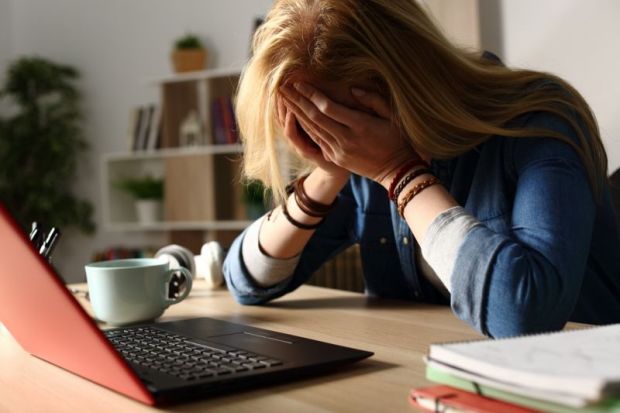 Stressed PhD student at laptop