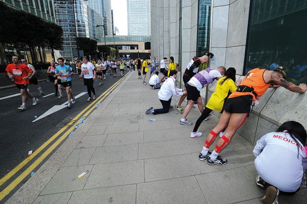 Runners try and stretch out their fatigue during the London Marathon Runners try and stretch out their fatigue to illustrate Low completion rates put OU on collision course with regulator