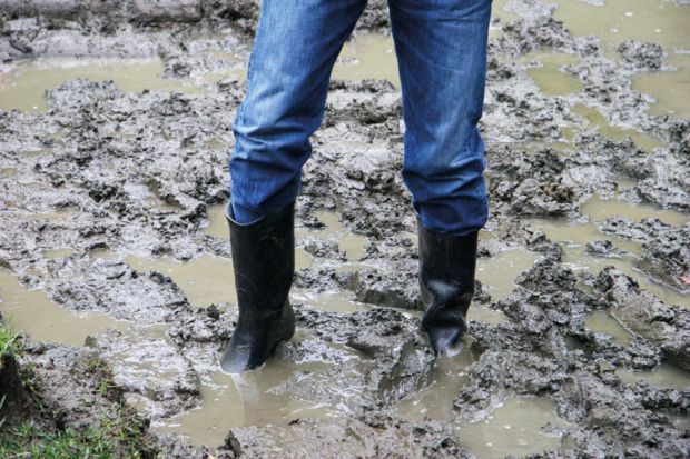 Man wearing boots stuck in the mud Man wearing boots stuck in the mud