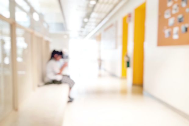 student sitting alone on walkway
