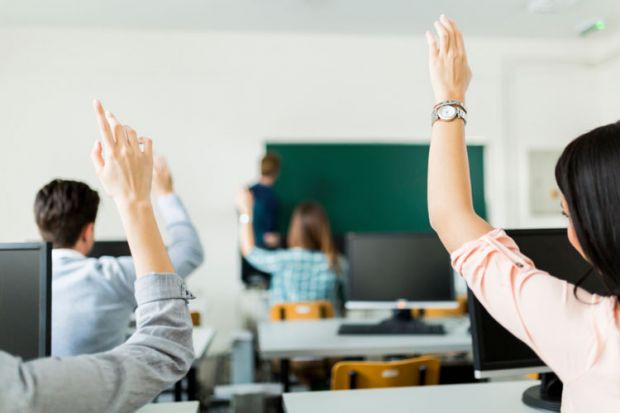 Students raising hands during lesson Students raising hands during lesson