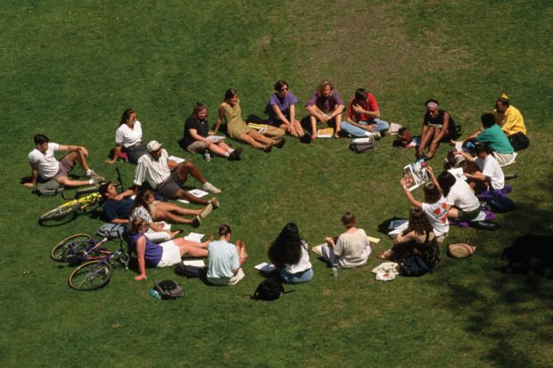 Students sitting in circle outside on lawn Students sitting in circle outside on lawn