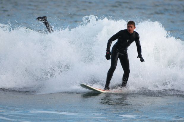 Surfer wiping out in small wave, Aberdeen Beach, Scotland Surfer wiping out in small wave, Aberdeen Beach, Scotland