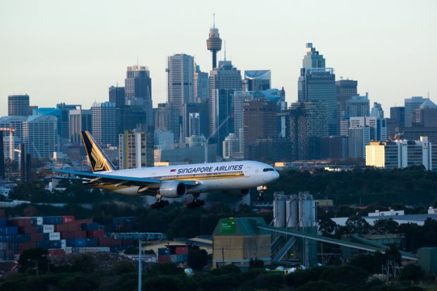 Sydney Australia May 13, 2014 Boeing 777 wearing Singapore Airlines livery approaching for landing at Kingsford Smith airport at Dusk , with the city Skyline in the background