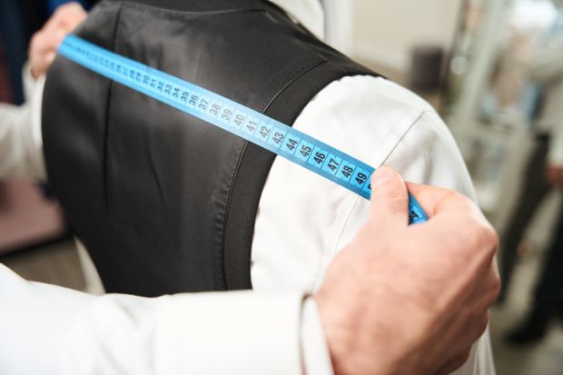 A tailor measuring someone for a suit, illustrating tailored employability training