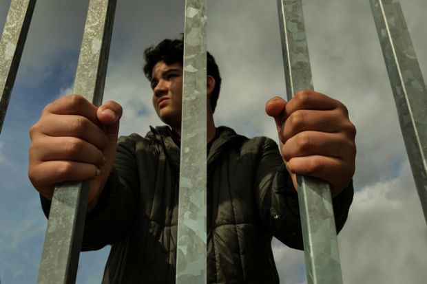 Teenage boy hands holding strong iron bar Teenage boy hands holding strong iron bar