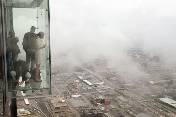 Visitors stand out on the Ledge, a glass cube that juts out from the 103rd floor Skydeck of the Sears Tower, Chicago Visitors stand out on the Ledge, a glass cube that juts out from the 103rd floor Skydeck of the Sears Tower, Chicago