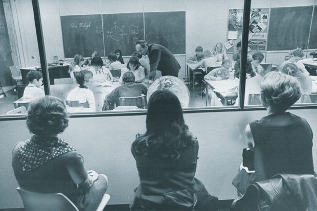 Three visiting teachers watch through a one-way window along the wall of a special demonstration classroom Three visiting teachers watch through a one-way window along the wall of a special demonstration classroom