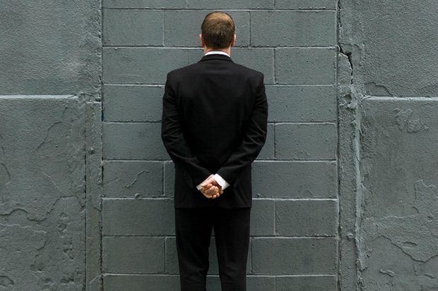 Man in front of brick wall