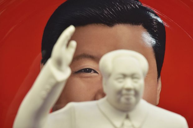 A decorative plate featuring an image of Chinese President Xi Jinping behind a statue of late communist leader Mao Zedong in a shop