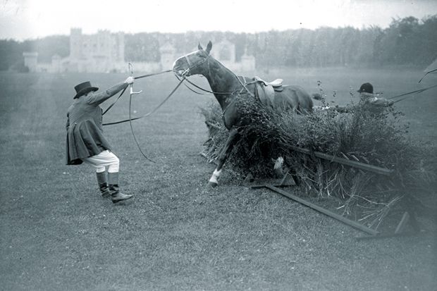 Man trying to make a horse get over a jump