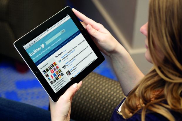 Young woman using Twitter on tablet PC